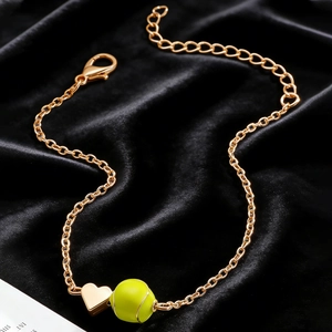 Vue macro du collier tennis doré avec pendentif coeur sur tissu en velours noir