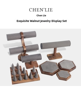 Detail view of walnut wood jewelry display set with gray velvet pads for necklaces