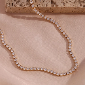 Macro detail of 14K gold plated tennis necklace with shimmering white zircon stones