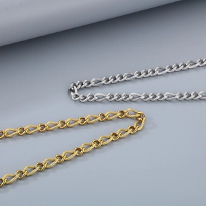 Detailed close-up of gold and silver plated Cuban link chains on a textured grey background