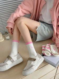 Detail of white cotton crew socks with pink cuffs and cute bunny embroidery