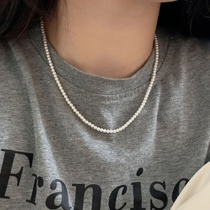 Close-up of minimalist 925 sterling silver necklace with 3-4mm petite white pearls