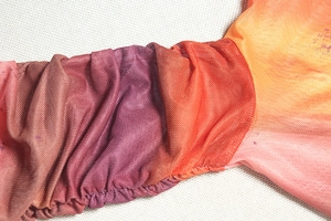 Detail of gradient pink and purple mesh fabric with elastic ruched texture