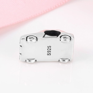 Macro shot of S925 sterling silver car bead charm with S925 hallmark on smooth pink silk