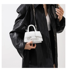 Close-up of white lychee texture mini bag with silver chain strap on model