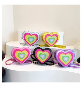 Close-up of heart-shaped crossbody bags in silver, yellow, pink, black and purple colors