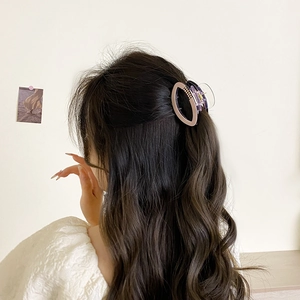 Elegant oval hair claw clip in pink and purple acrylic shown on model back of head