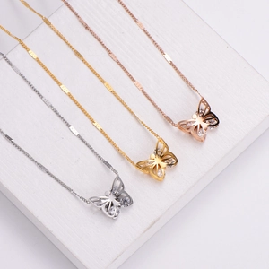 Three hollow butterfly pendant necklaces in silver, gold, and rose gold with shiny zircons