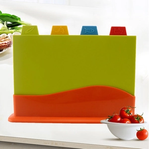 Set of four color-coded plastic cutting boards with icons in an orange storage base