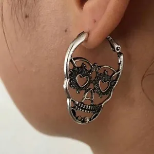Retro silver hollow skull earrings with heart-shaped eyes in a gothic punk style