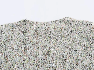 Gros plan sur un tissu en tweed pailleté multicolore aux tons pastel vert, rose et jaune