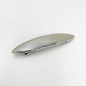 Detail shot of silver metal hair clip featuring a refined striped texture and spring clasp