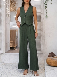 Detail of dark green linen vest and wide-leg trousers set in a stylish resort aesthetic