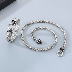 Silver punk style skull head stainless steel bracelet and necklace set on gray background