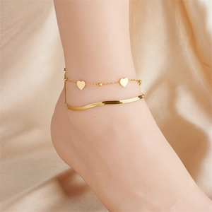 Double-layer gold plated heart anklet with snake chain on satin background