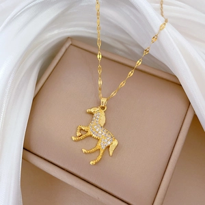 Detail of a horse pendant with crystals on a gold chain over silk background