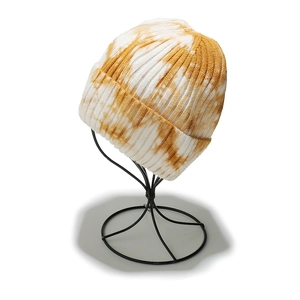 Detailed close-up of ribbed knit texture on a yellow and white tie-dye beanie