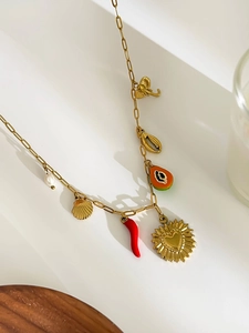 Detail view of 18K gold bohemian necklace with elephant shell and chili charms