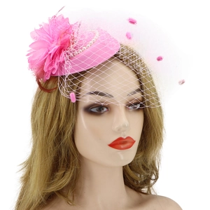 Pink fascinator hat with flower, white pearls, and mesh veil on a mannequin head