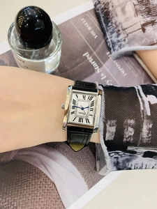Elegant rectangular silver watch with roman numerals on wrist with lifestyle backdrop