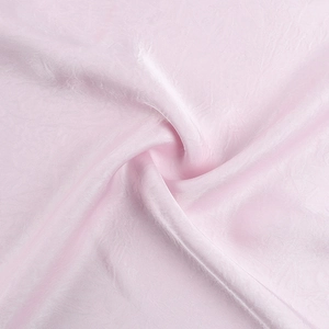 Detail of pink satin fabric showing elegant ruched texture and silky pleated drapes