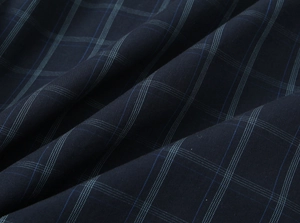 Detailed close-up of navy blue plaid poplin fabric with soft textured woven folds