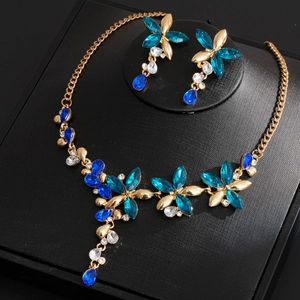 Vintage floral jewelry set with blue rhinestones on a professional display stand