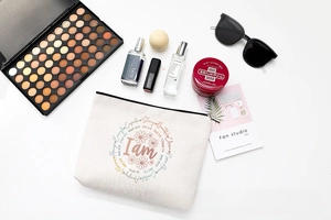 Flat lay of linen makeup bag with floral print and toiletries on white background
