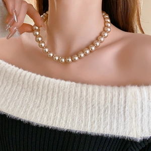 Elegant French vintage champagne pearl necklace worn on a model for a sophisticated look