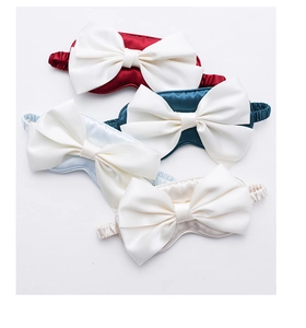 Detail view of multi-colored silk eye masks with decorative large bows in four elegant shades