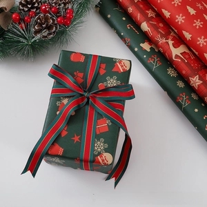 Close-up of festive Christmas gift wrap with gold reindeer patterns and matching ribbons