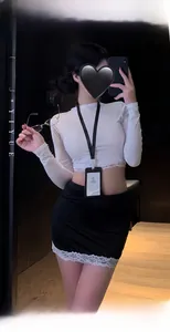 Détail du crop top en dentelle et de la jupe moulante noire d'un ensemble uniforme sexy