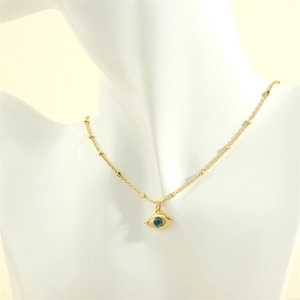 Close-up of golden Evil Eye pendant necklace with blue stone on a white mannequin bust