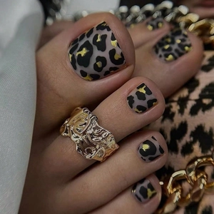 Gold textured ring with leopard print toenail patches in a stylish fashion setup