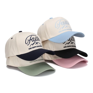 Close-up of FAITH embroidery on multi-color canvas baseball caps stacked together