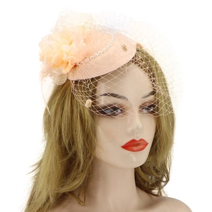 Detailed close-up of pink fascinator hat with feathers, flowers, and delicate pearl mesh