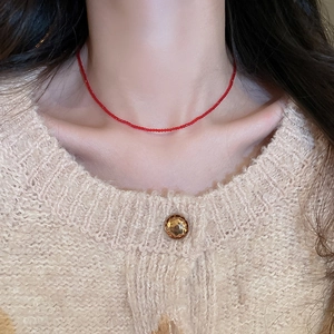 Close-up of minimalist red crystal beaded choker necklace worn on model neck