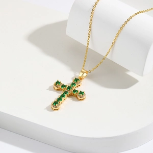 Collana a croce placcata oro 18K con zircone verde smeraldo su espositore pulito
