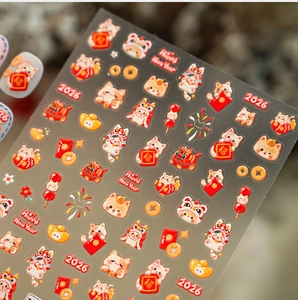 Macro view of 2026 Lunar New Year nail stickers with cute lion dance cats and red envelopes