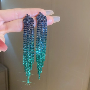 Detailed close-up of long tassel earrings with blue to green gradient rhinestones