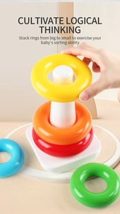 Close-up of baby stacking colorful rings on a white base to develop logical thinking skills
