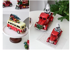 Detail of red vintage Christmas truck and bus ornaments with miniature pine trees
