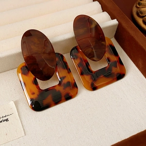 Detail of amber tortoiseshell resin geometric earrings with square and oval links