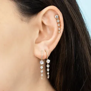 Macro view of gold S925 silver earrings with sparkling cubic zirconia and tassels