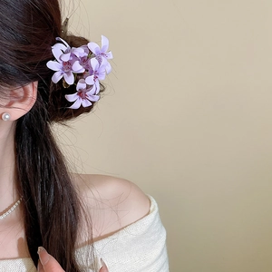 Detail of elegant light purple fabric flower hair pin with delicate petals and stamen