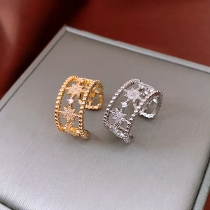 Detail of gold and silver hollow star rings featuring white zircon and beaded edges