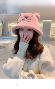 Detail of pink plush bucket hat with teddy bear ears and white embroidered text
