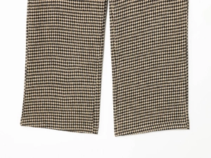 Detailed view of houndstooth trousers showing the classic brown and black woven fabric texture