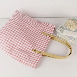 Pink and white checkered canvas tote bag with brown faux leather handles on white background