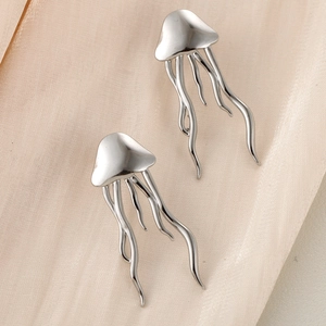 Elegant silver stainless steel jellyfish stud earrings on a beige silk background